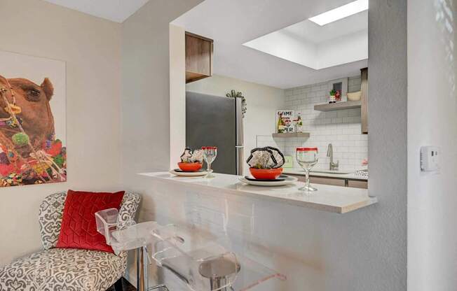 A kitchen with a white counter and a painting of a camel on the wall.