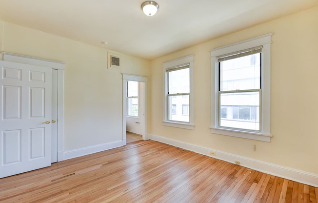 vacant bedroom with hardwood floors, and large windows at twin oaks apartments columbia heights washington dc