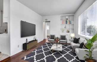 a living room with a couch coffee table and a tv on the wall