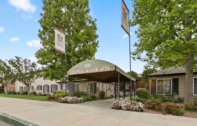 Apartments for rent in Van Nuys - Exterior View of Colonial Manor Apartments in Van Nuys with Gated Entrance and Lush Landscaping