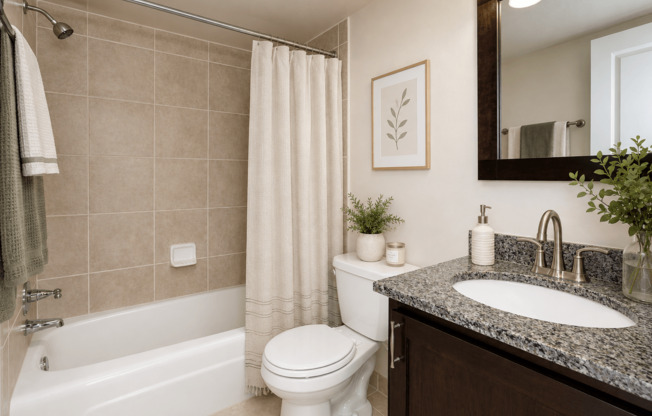 A bathroom with a white toilet, a white bathtub, a sink, and a mirror.
