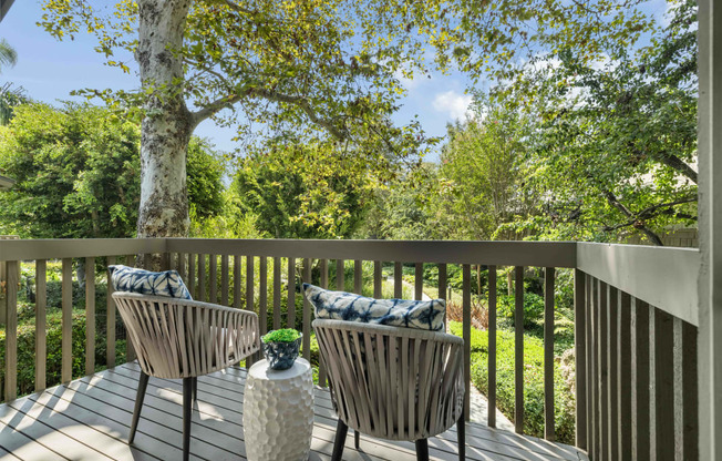 a patio with chairs and a table on a deck