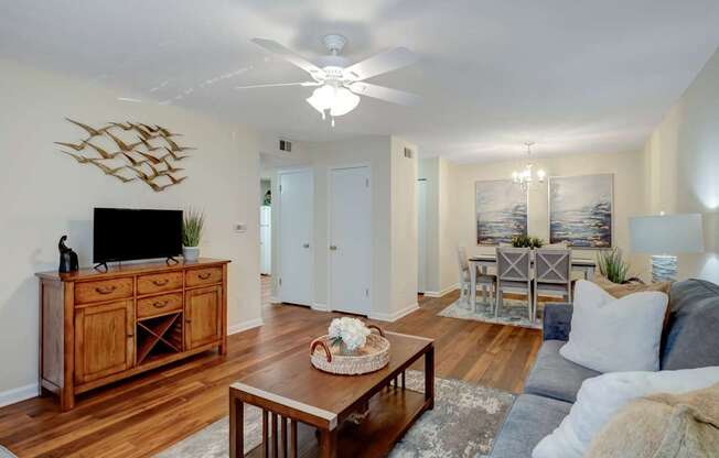 A living room with a wooden cabinet and a flat screen TV on top of it.