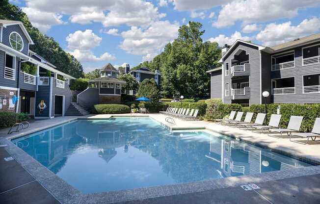 A large swimming pool in front of apartment buildings.