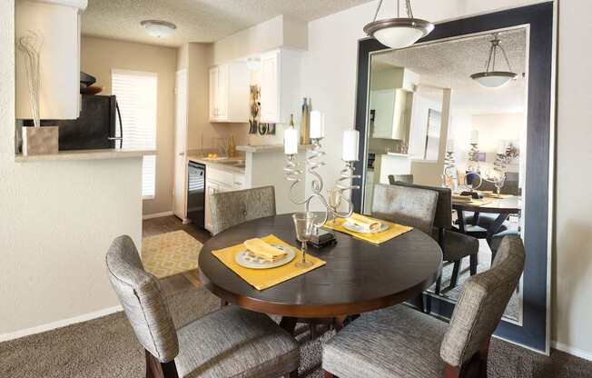 A dining room with a round table set for two.