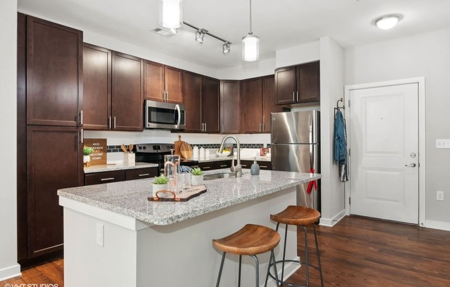 a kitchen with a marble counter top and wooden cabinets