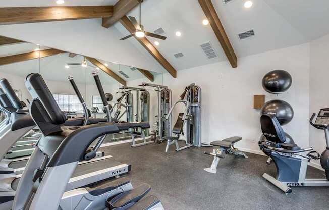 A spacious gym with a variety of equipment including treadmills, weights, and exercise balls.