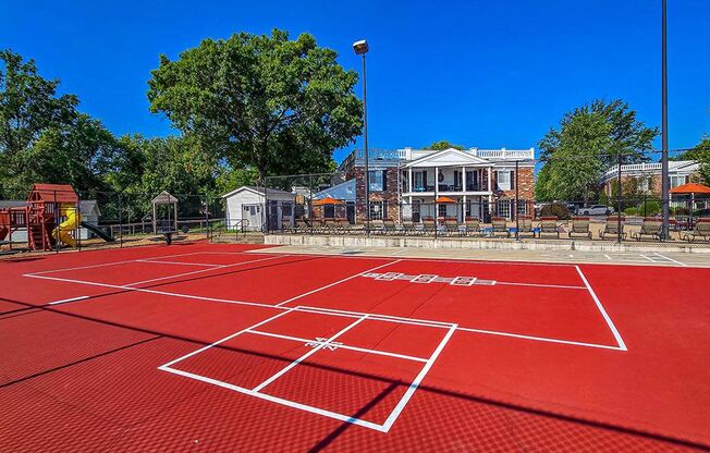 a tennis court with a house in the background