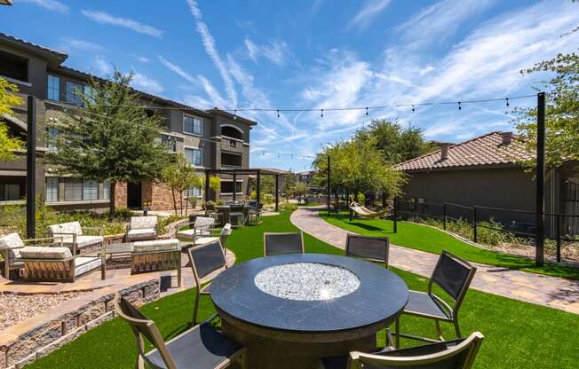 an outdoor patio with a round table and chairs