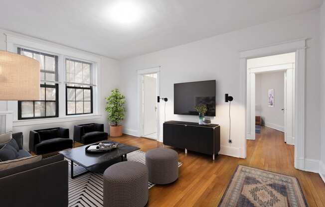 a living room with black furniture and a tv