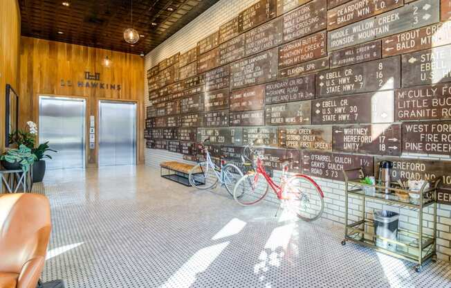a room with a wall of wooden signs on the wall and two bikes in front of it