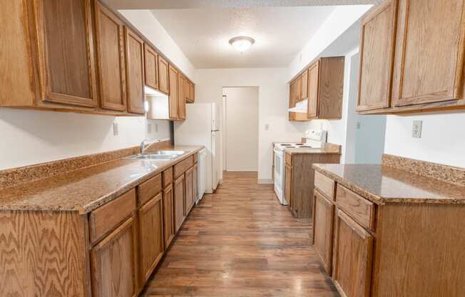 a kitchen with wooden cabinets and counters and a white refrigerator