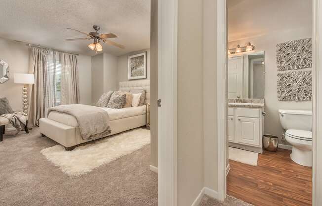 a bedroom and bathroom with a ceiling fan at Highland Ridge Apartments, Overland Park 