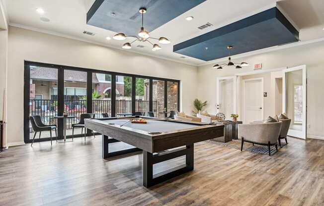 A room with a pool table and a chair.