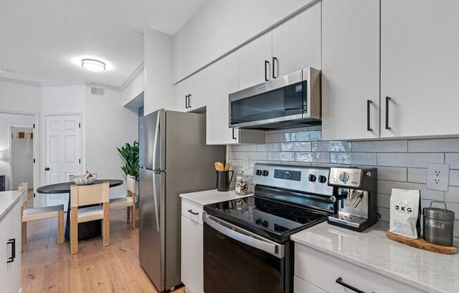 a kitchen with stainless steel appliances and white cabinets