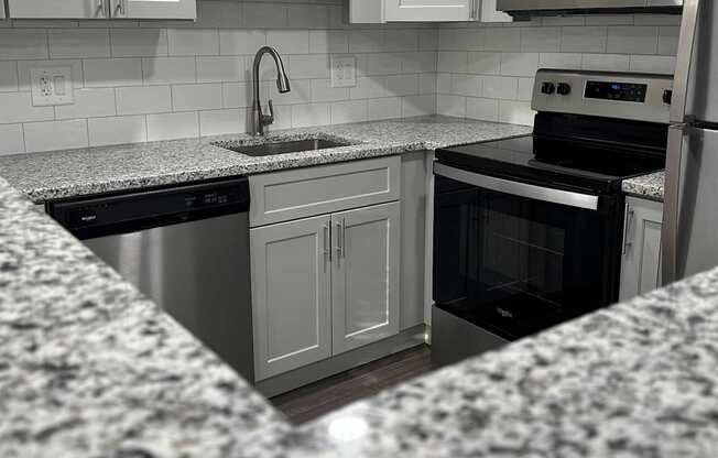 A kitchen with granite countertops and stainless steel appliances.