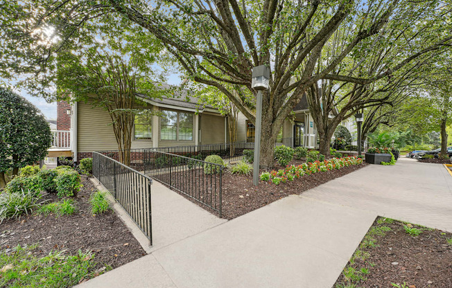 A tree-lined walkway leads to a building.