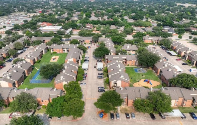A bird's eye view of a residential area with houses, cars, and a playground.