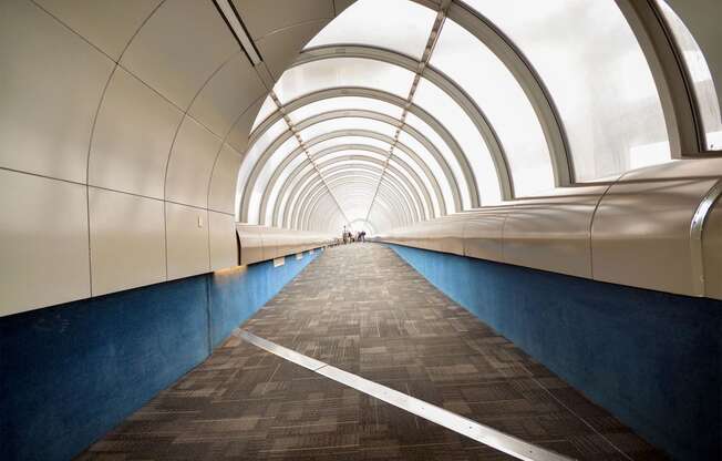 a tunnel with blue walls and white light at the end