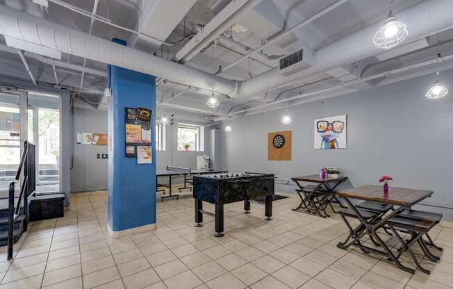 a room with a foosball table and tables with chairs at The Lofts at 5 Lyon, in downtown Grand Rapids, MI