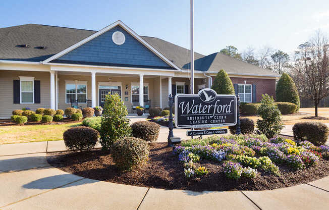 A sign for Waterford Residential Club in front of a building.