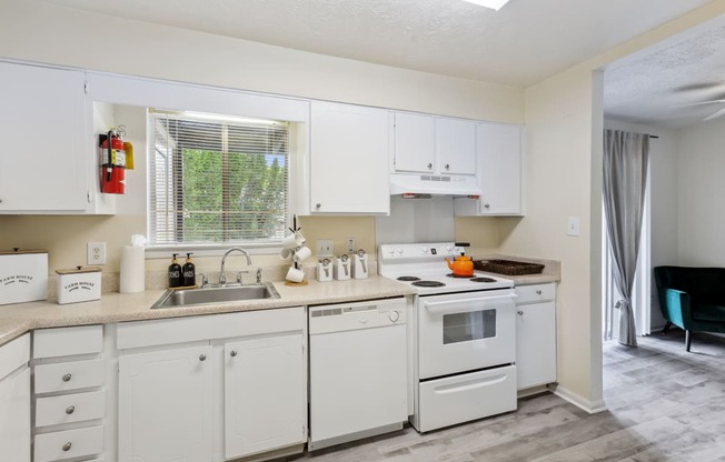 a kitchen with white cabinets and appliances and a sink