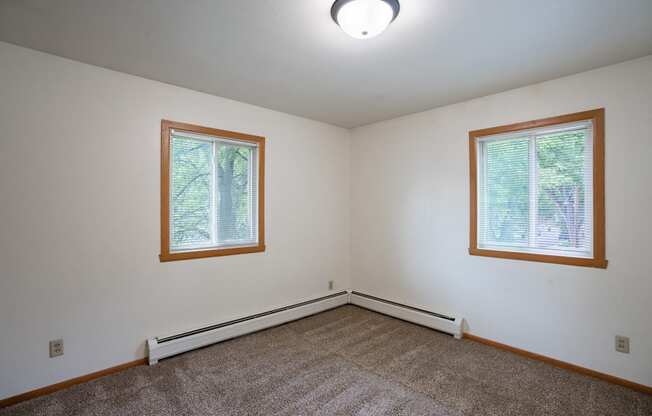 a bedroom with two windows. Fargo, ND Crown Court 1 Apartments