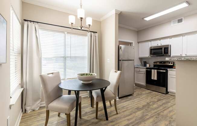 a kitchen and dining room with a table and chairs