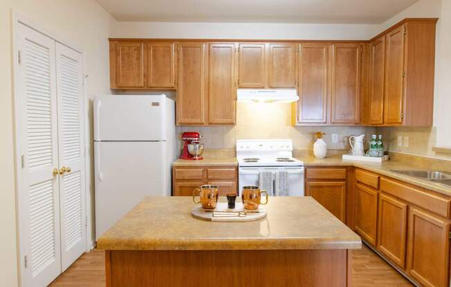 A kitchen with wooden cabinets and a white refrigerator.