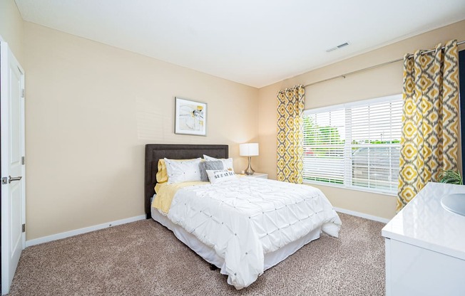 a bedroom with a bed and a large window