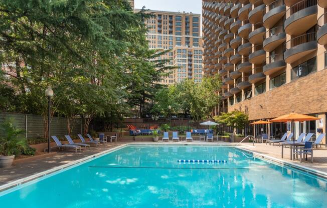 a swimming pool at a hotel with a building in the background