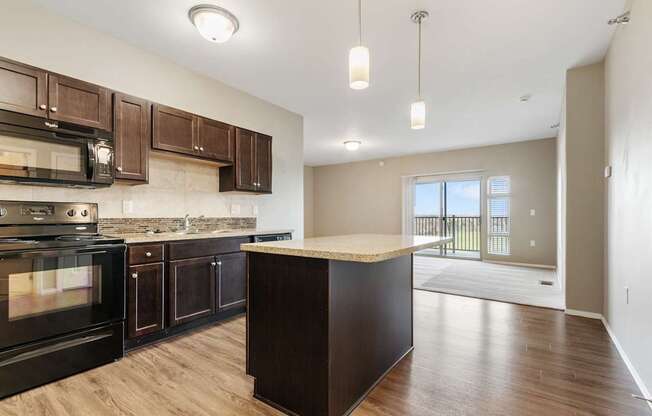 A kitchen with dark wood cabinets and a black oven.