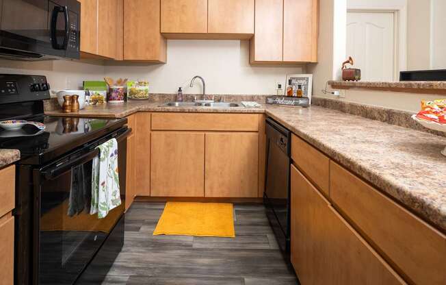 A kitchen with wooden cabinets and a black stove top.