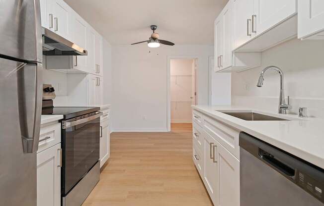 A kitchen with white cabinets and stainless steel appliances.