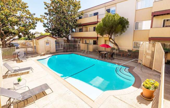 A swimming pool surrounded by a fence and trees.
