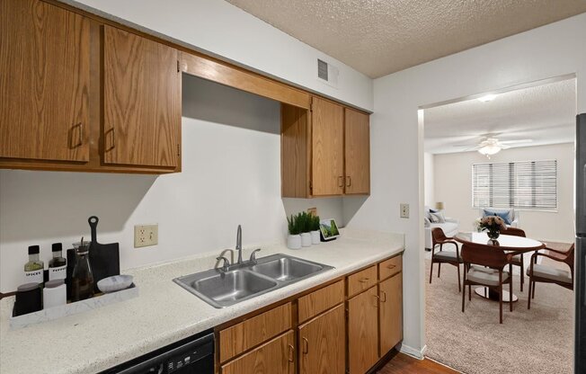 a kitchen with a sink and cabinets and a dining room