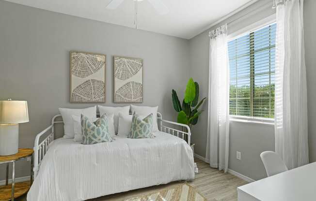 a bedroom with a white bed and two pictures on the wall