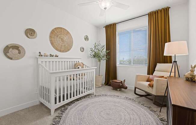 A baby's room with a white crib and a brown chair.
