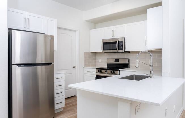 a kitchen with stainless steel appliances and a white counter top