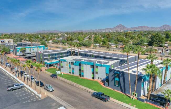 an aerial view of a building with palm trees and a parking lot