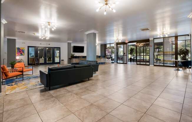 a large lobby with couches and chairs and sliding glass doors