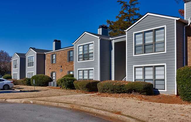 A row of houses with a car parked in front of them.
