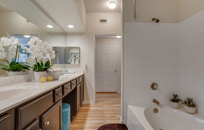 View of Bathroom with Garden Tub, Double Sink, and Plank-Wood Flooring with Raveneaux Apartments