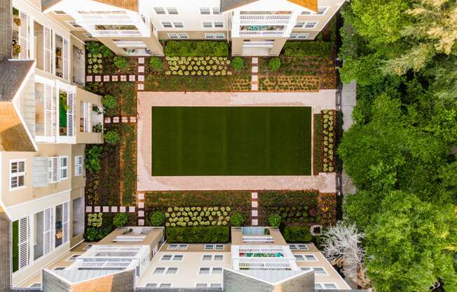 an aerial view of the courtyard of a building with a green lawn