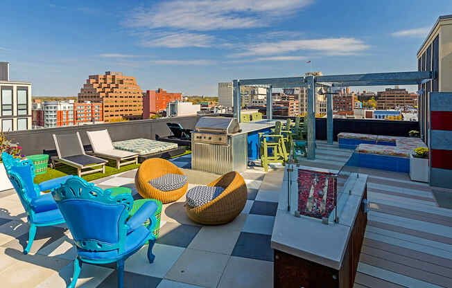 a rooftop terrace with chairs and tables and a city in the background at Ann Arbor City Club, Michigan