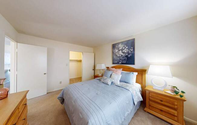 A bedroom with a bed, nightstand, and lamp.