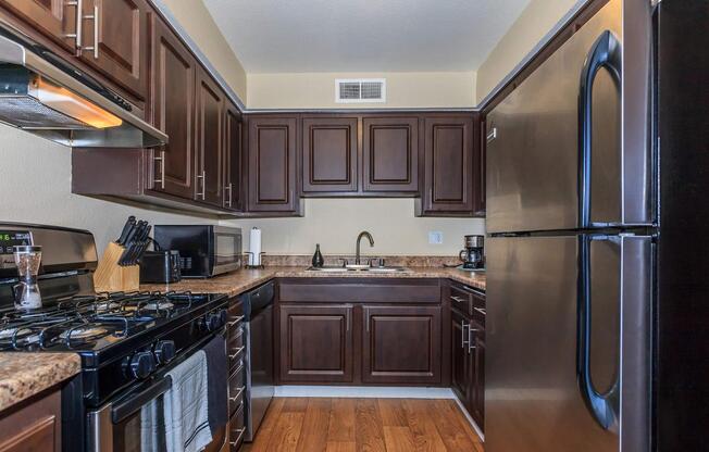 a modern kitchen with stainless steel appliances and wooden cabinets