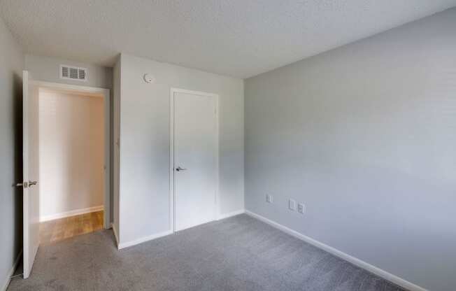 A room with a carpeted floor and two doors.