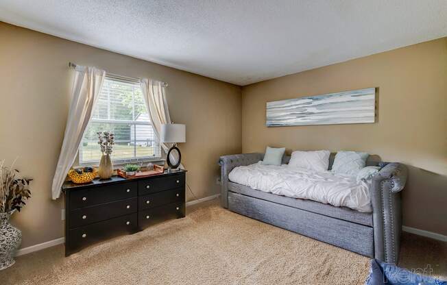 a bedroom with a bed and a dresser and a window