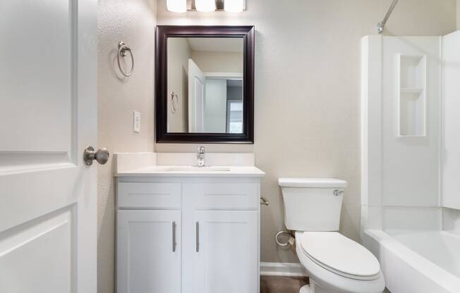 a bathroom with a toilet sink and a mirror